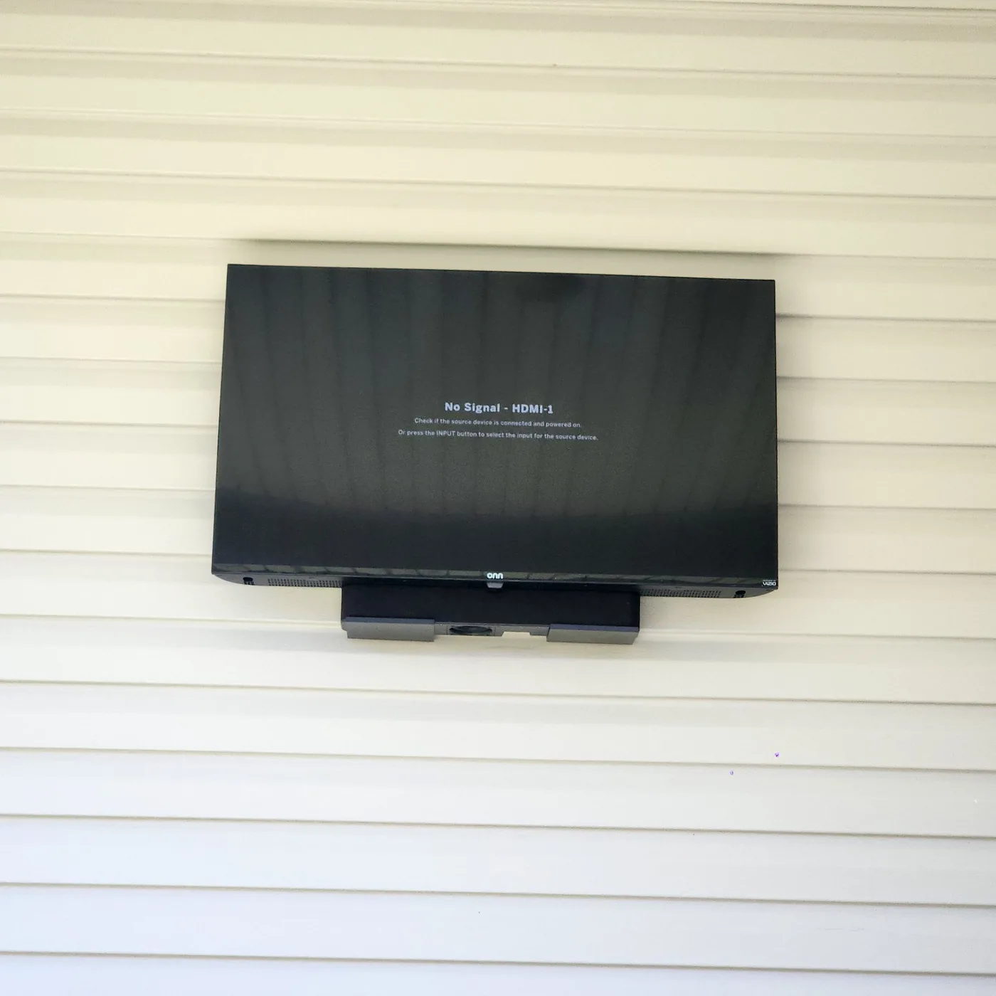 Outdoor television mounted on a covered patio wall